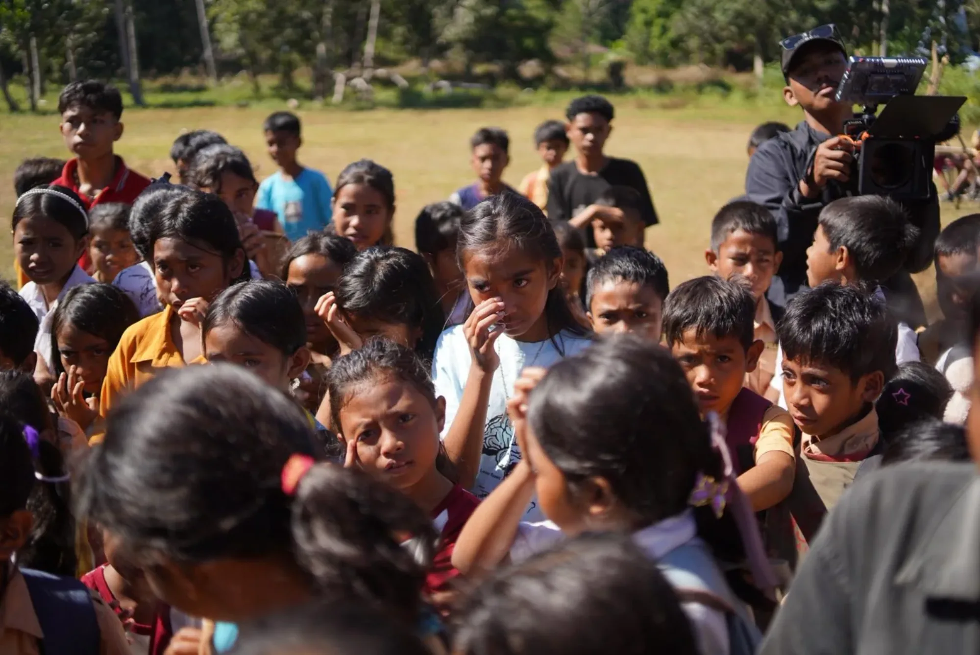 Sekelompok anak berkumpul di luar ruangan di Sumba pada siang hari.